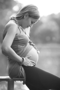 A pregnant women looking down at her tummy with her hands around her bump, Jo Kellett, from the seed, Brighton