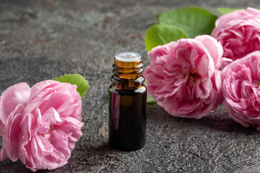 fertility massage in brighton - essential oil bottle with roses on flatly