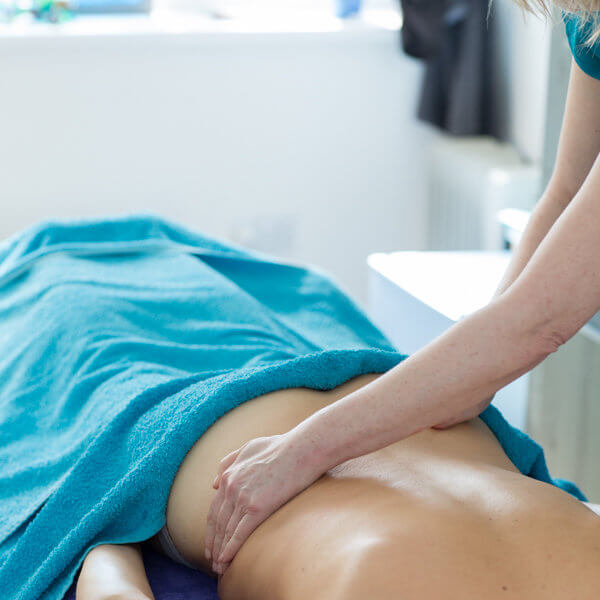 aromatherapy massage in brighton - hands on lower back with towel covering body